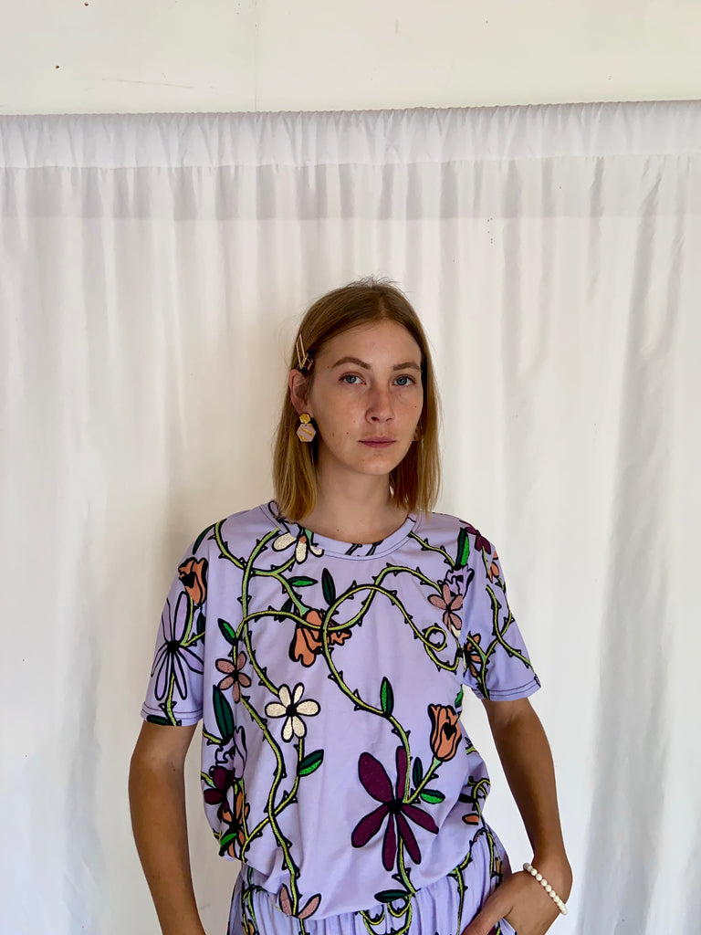 aan foto van deze pièce unique t-shirt in lila met geborduurde bloemen met de bijpassende broek