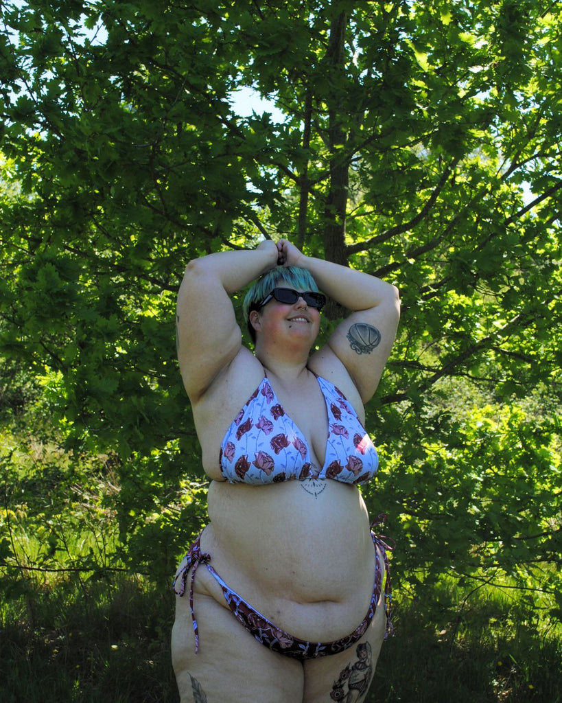 Vooraanzicht van de koordbikini. Het broekje is donkerrood en heeft een speelse bloemenprint in roze, blauw en bordeaux