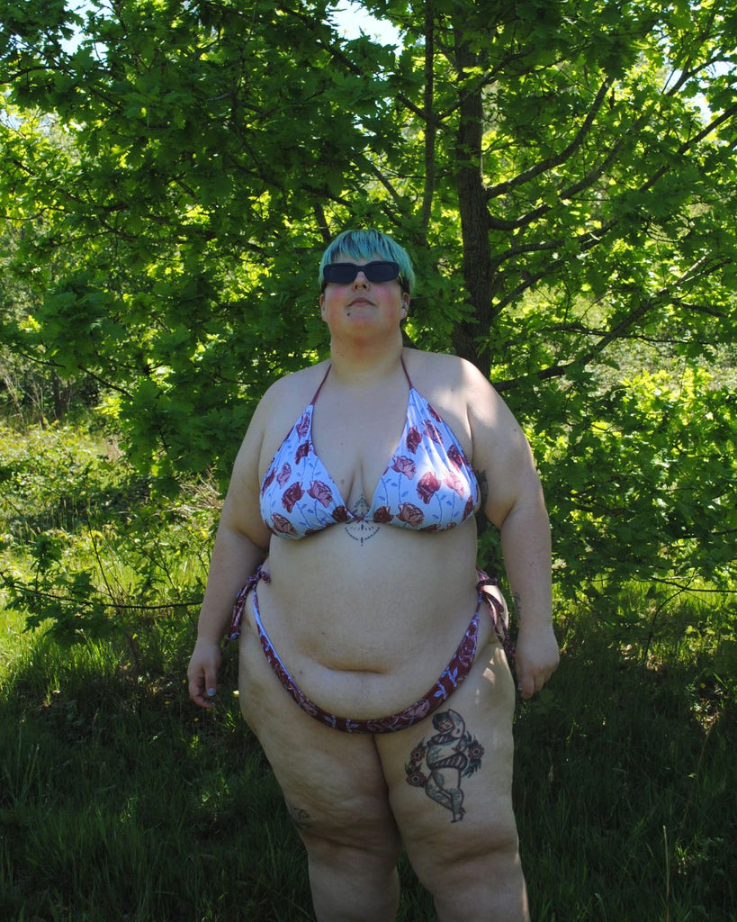Achteraanzicht van de koordbikini. Het broekje is donkerrood en heeft een speelse bloemenprint in roze, blauw en bordeaux